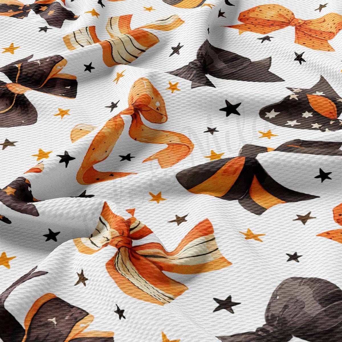 a close-up view of a fabric with a repeating pattern of orange and black bows, along with scattered stars.
