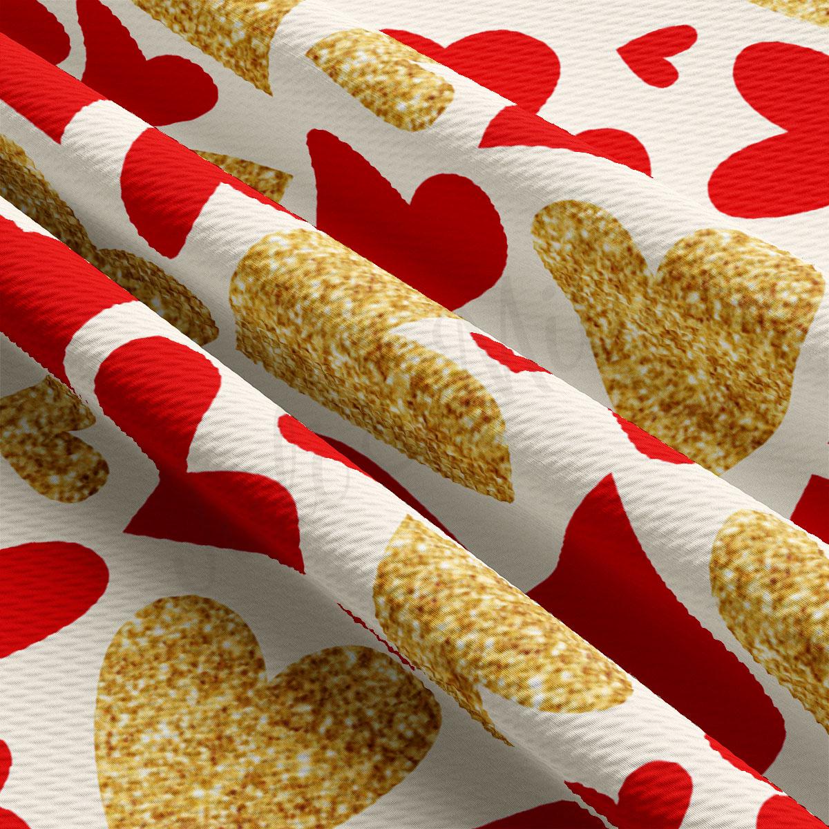 a close-up view of a fabric with a repeating pattern of red and gold hearts. The fabric appears to be made of a shiny, glittery material, giving it a festive and celebratory appearance.