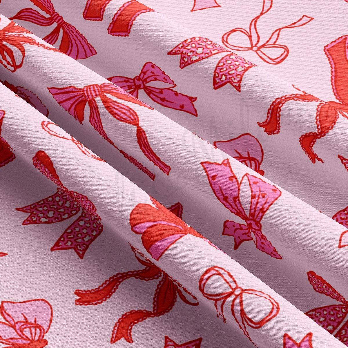 a close up of a pink fabric with red bows