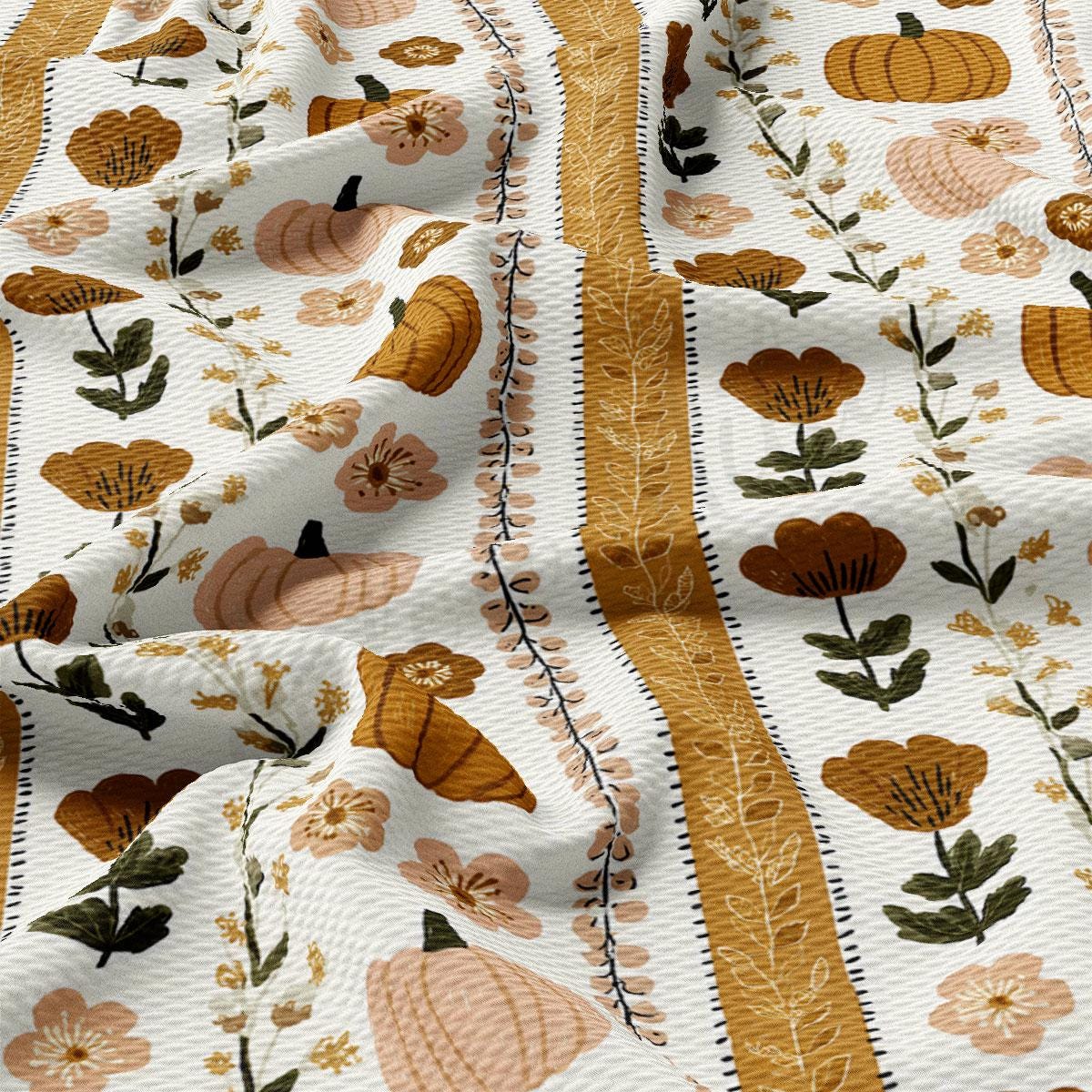 a close-up view of a fabric with a repeating pattern of autumn-themed elements, including pumpkins, flowers, and leaves. The fabric has a white background with a yellow border, creating a visually appealing and seasonal design.