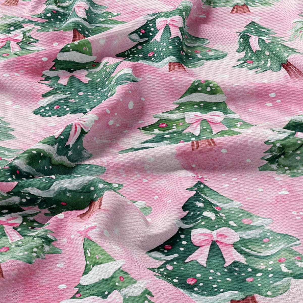 a close-up view of a fabric with a repeating pattern of Christmas trees and snowflakes in shades of pink and green.