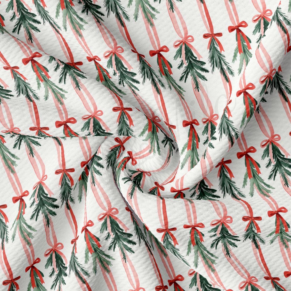 a close-up view of a fabric with a repeating pattern of Christmas trees and red bows.