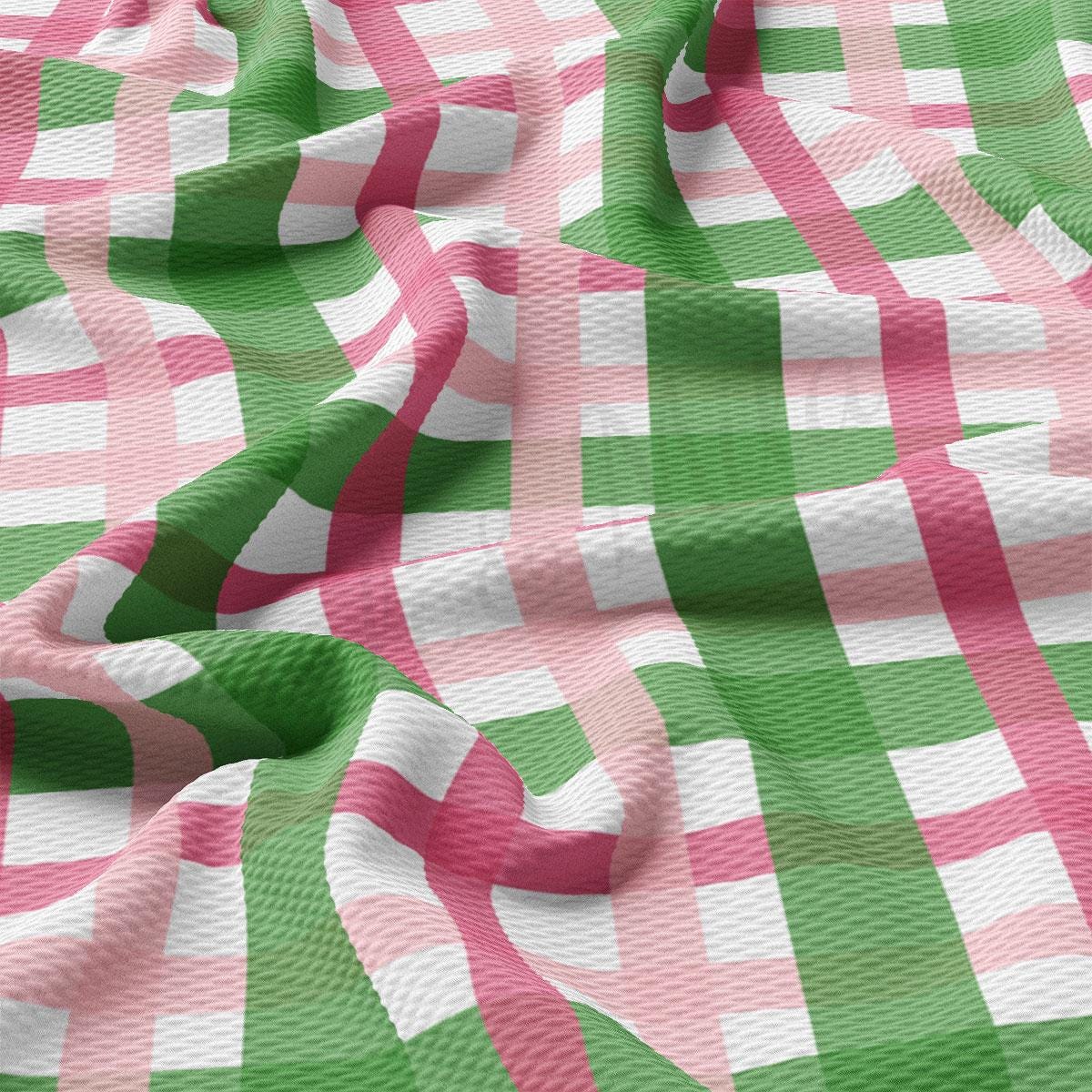 a green and pink checkered fabric with a white background