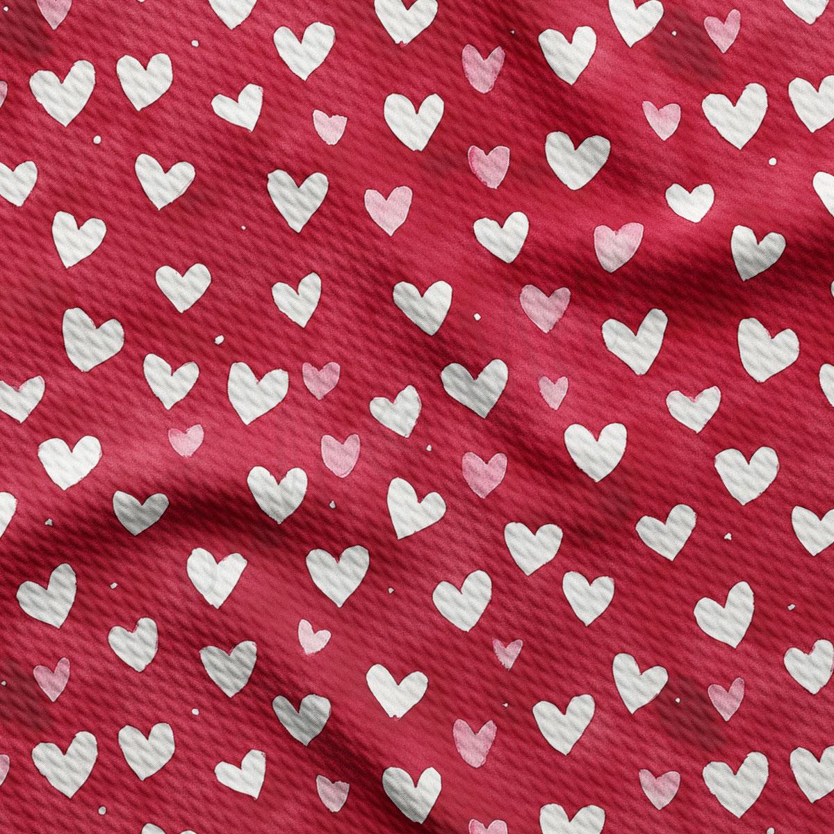 a close-up view of a red fabric with white hearts printed on it. The hearts are arranged in a repeating pattern, creating a visually striking and textured design.