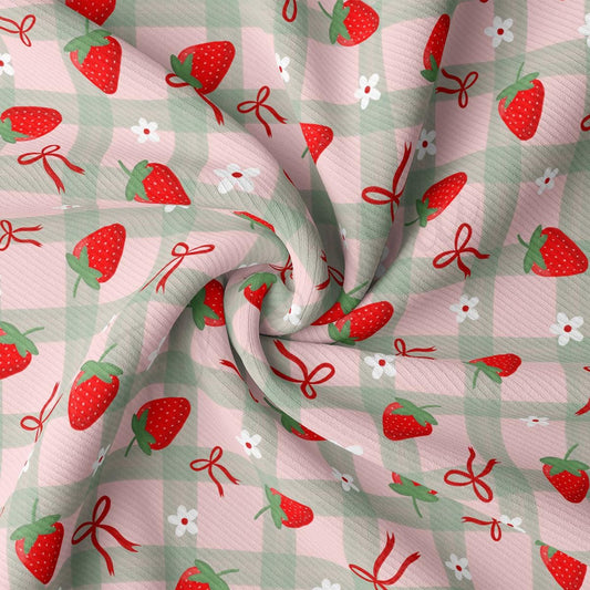 a pink and green checkered fabric with strawberries on it