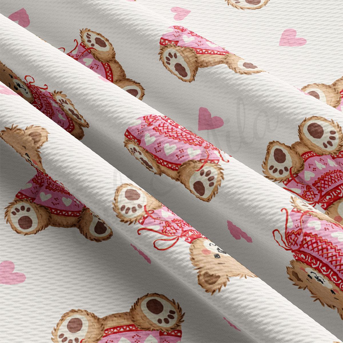 a close-up view of a fabric with a repeating pattern of teddy bears wearing pink sweaters and red scarves.