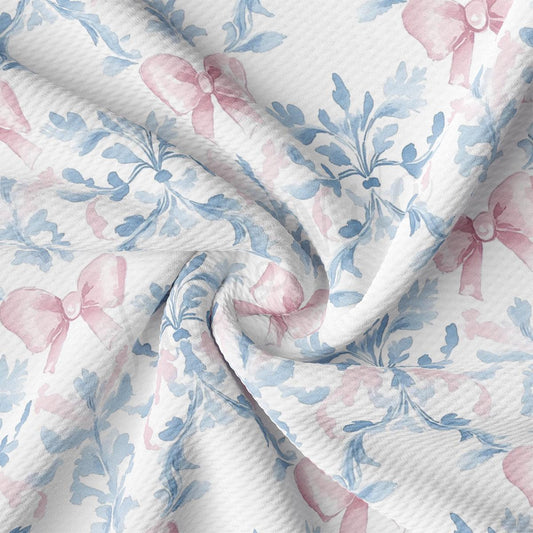 a close-up view of a fabric with a floral pattern in shades of blue and pink. The fabric appears to be wrinkled, giving it a textured and soft appearance.