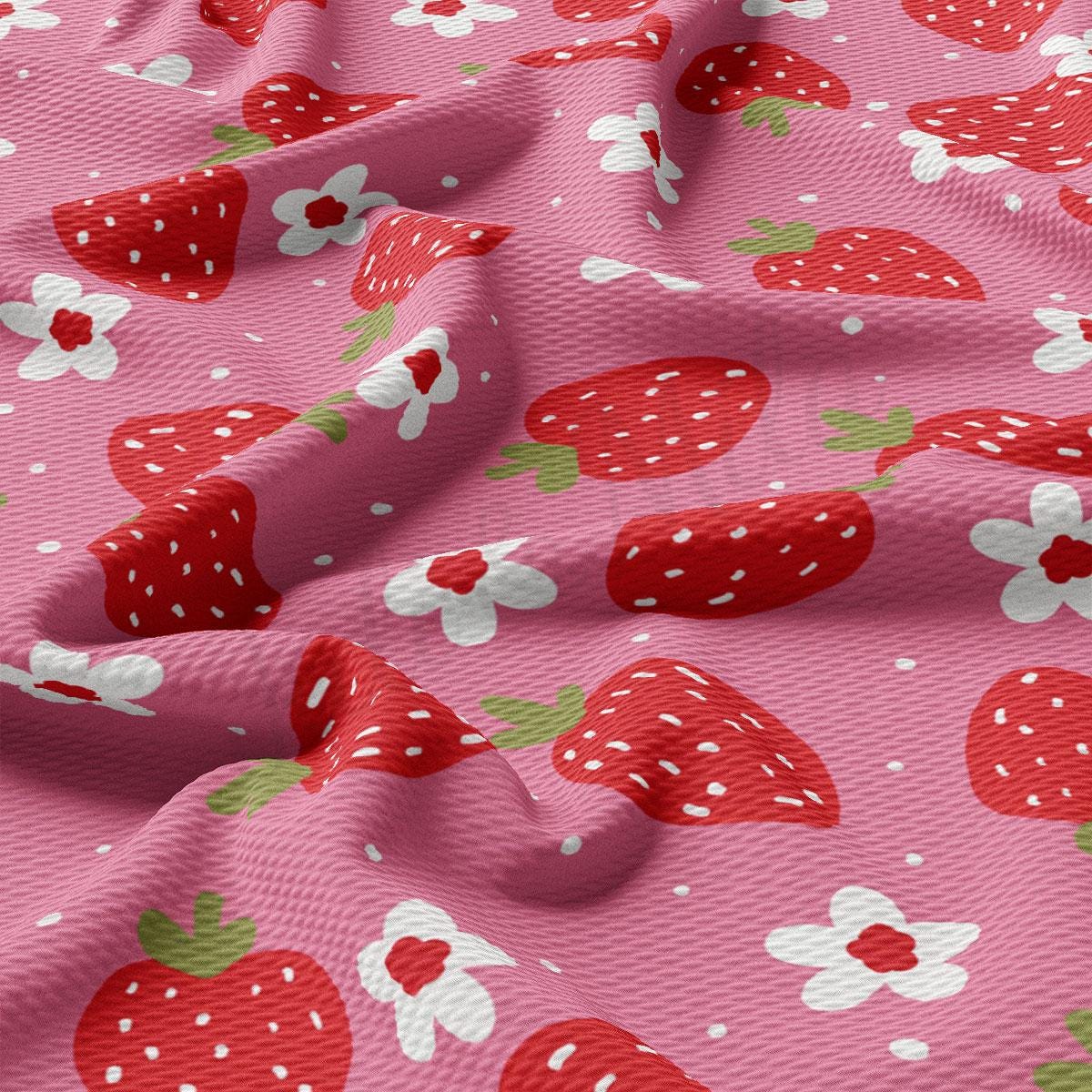 a pink fabric with strawberries and flowers on it