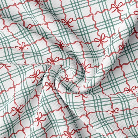 a close-up view of a fabric with a repeating pattern of green and red checkered lines and red bows.