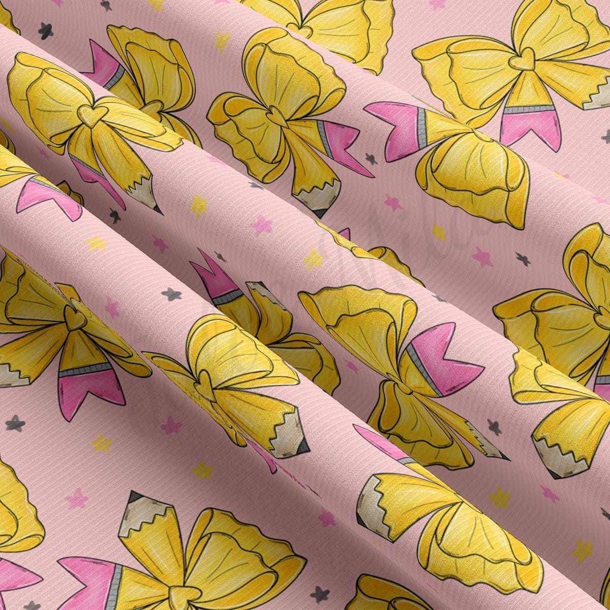 a fabric with a repeating pattern of yellow and pink bows and pencils on a pink background.