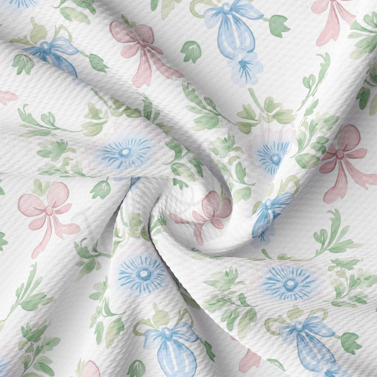 a close-up view of a fabric with a floral pattern, including blue and pink flowers and leaves. The fabric appears to be white and has a crinkled texture, giving it a soft and delicate appearance.
