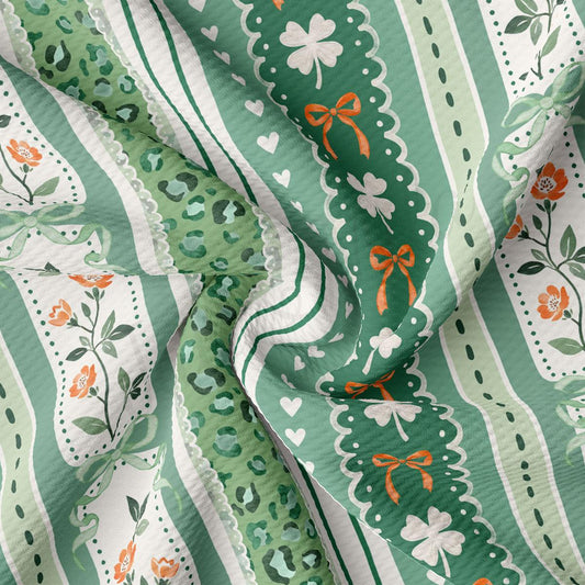 The image is a close-up of a fabric with a repeating pattern of green and white stripes, along with floral and leopard print elements. The fabric appears to be made of a soft, textured material, and the colors are vibrant and eye-catching.