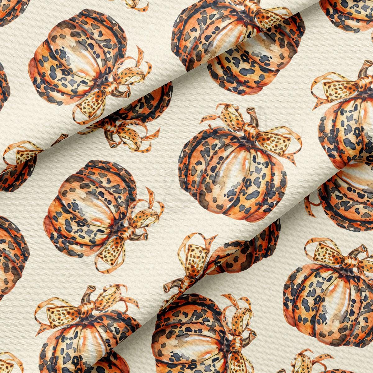 a repeating pattern of leopard print pumpkins with bows on a white background.