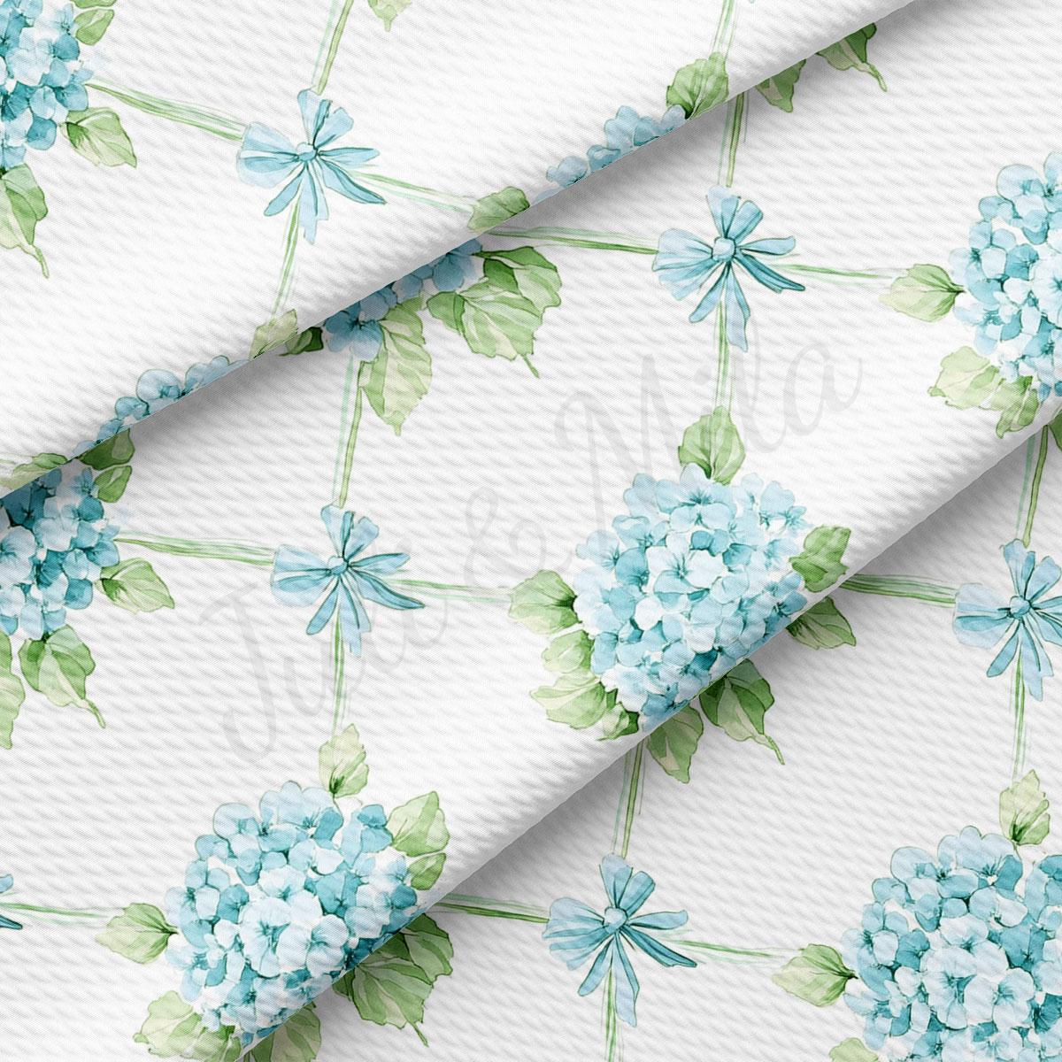 a repeating pattern of blue hydrangea flowers and green leaves on a white background.