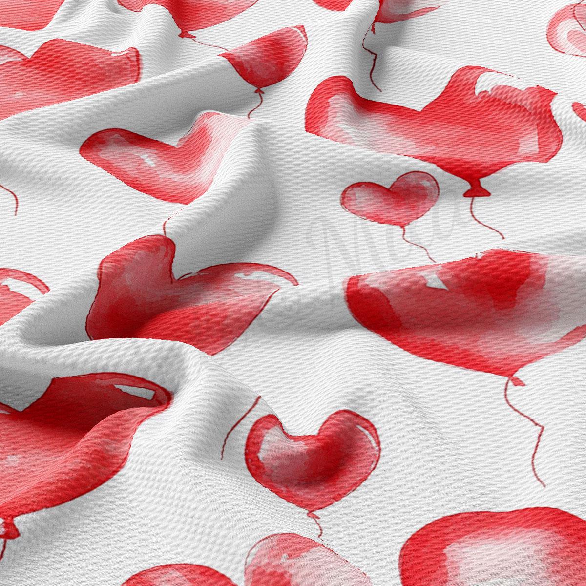 a close-up view of a fabric with a repeating pattern of red heart-shaped balloons.