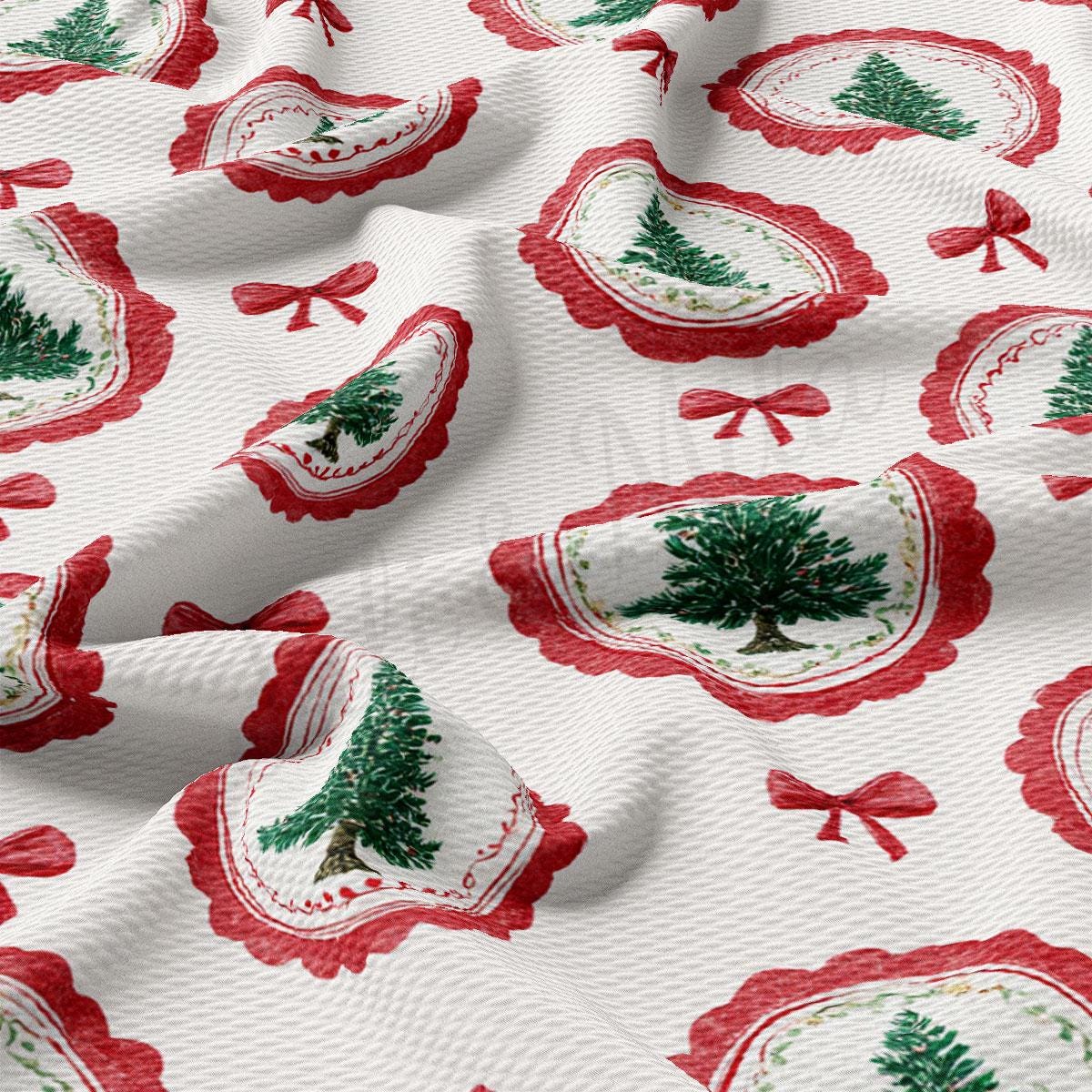 a close-up view of a fabric with a repeating pattern of Christmas tree designs and red bows.
