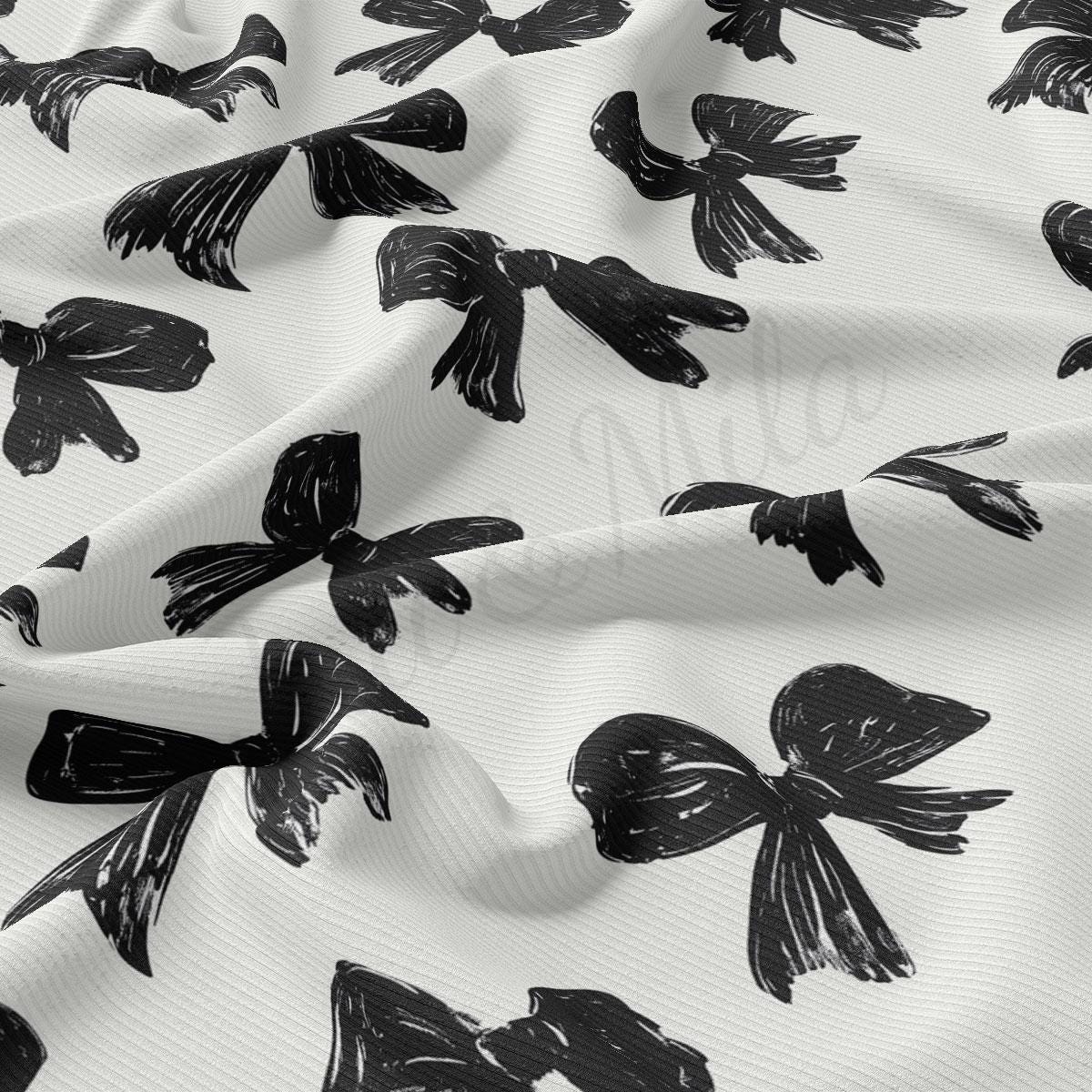 a close-up view of a fabric with a repeating pattern of black bows on a white background.