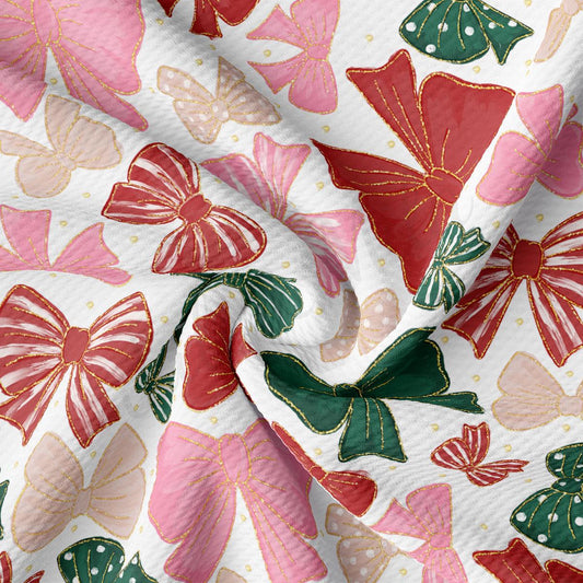 a close-up view of a fabric with a repeating pattern of red and green bows against a white background.