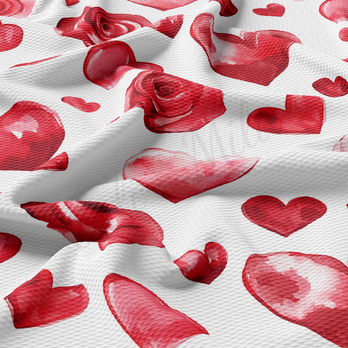 a close-up view of a fabric with a repeating pattern of red hearts and roses. The pattern is predominantly red and white, with the hearts and roses being the main focus. The fabric appears to be made of a soft, textured material, and the image is slightly crumpled, giving it a casual and relaxed appearance.
