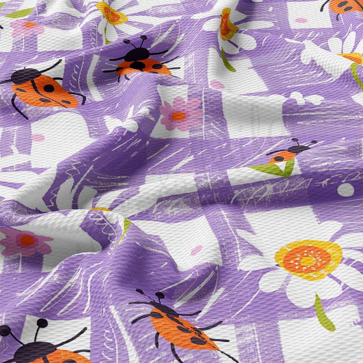 a close up of a purple and white fabric with ladybugs on it