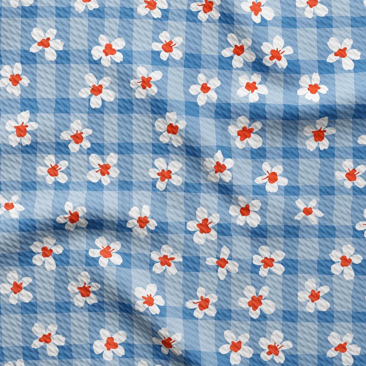 a blue and white checkered fabric with red and white flowers