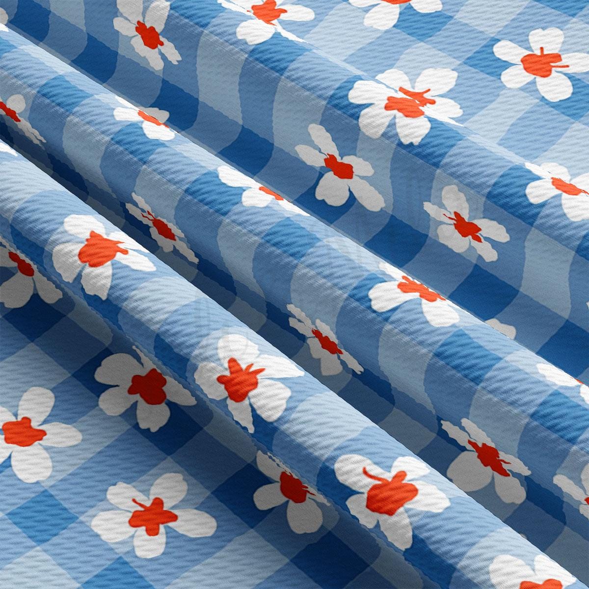 a blue and white checkered fabric with red and white flowers