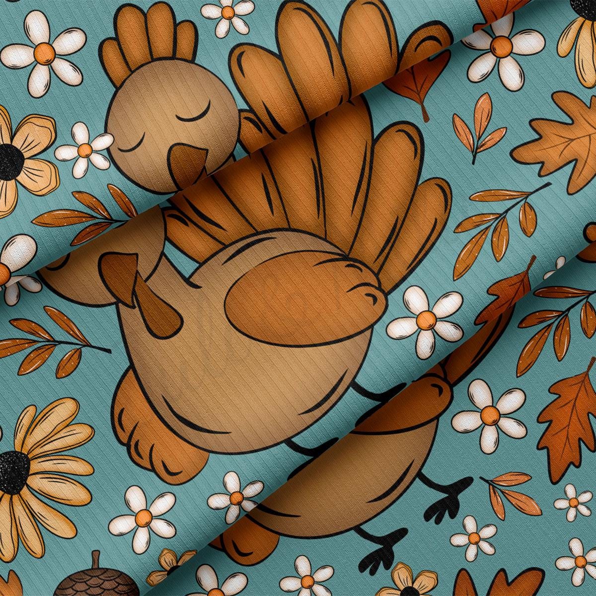 a close-up view of a turquoise fabric with a playful illustration of a turkey surrounded by autumn leaves, flowers, and pine cones.
