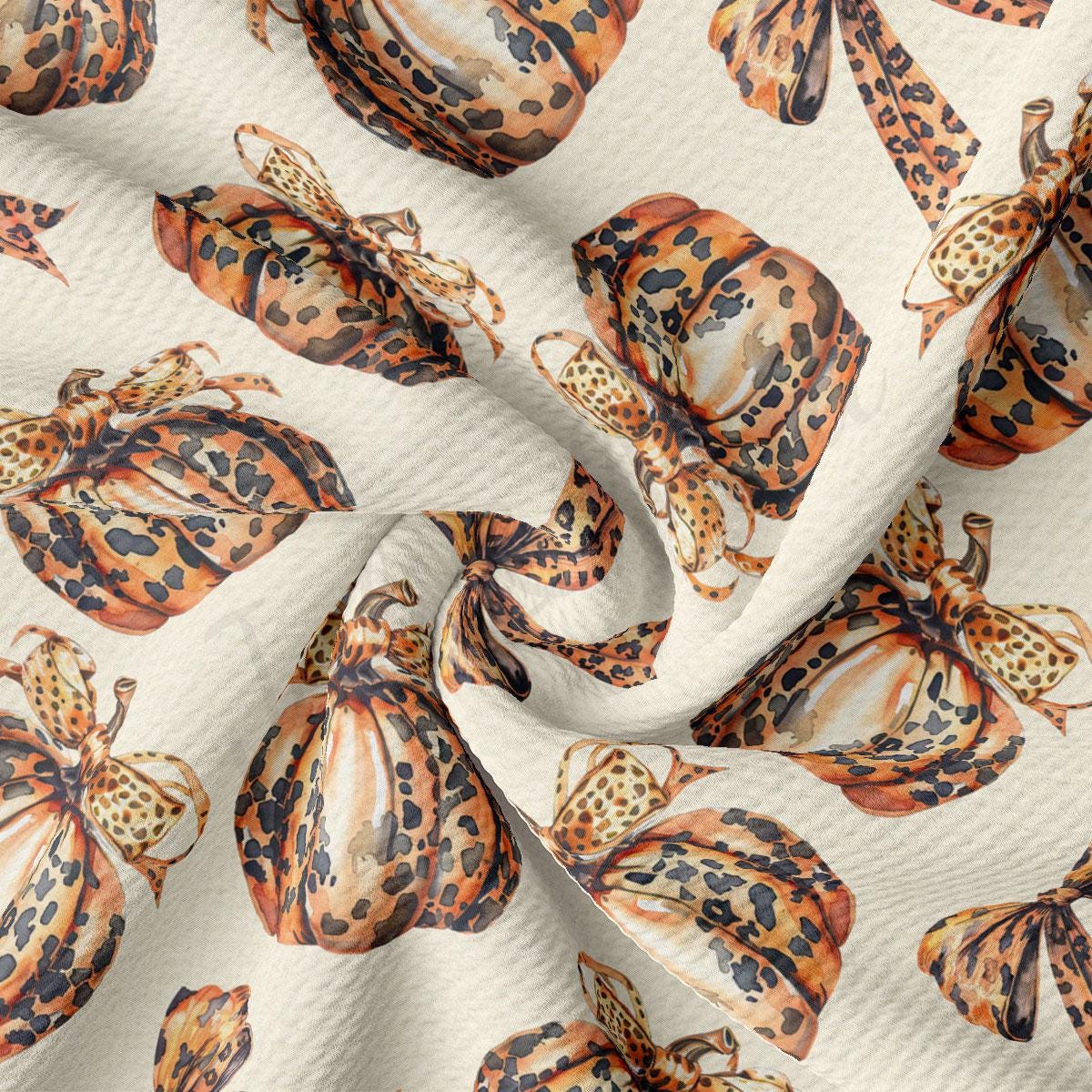 a close-up view of a fabric with a repeating pattern of leopard print pumpkins and butterflies.