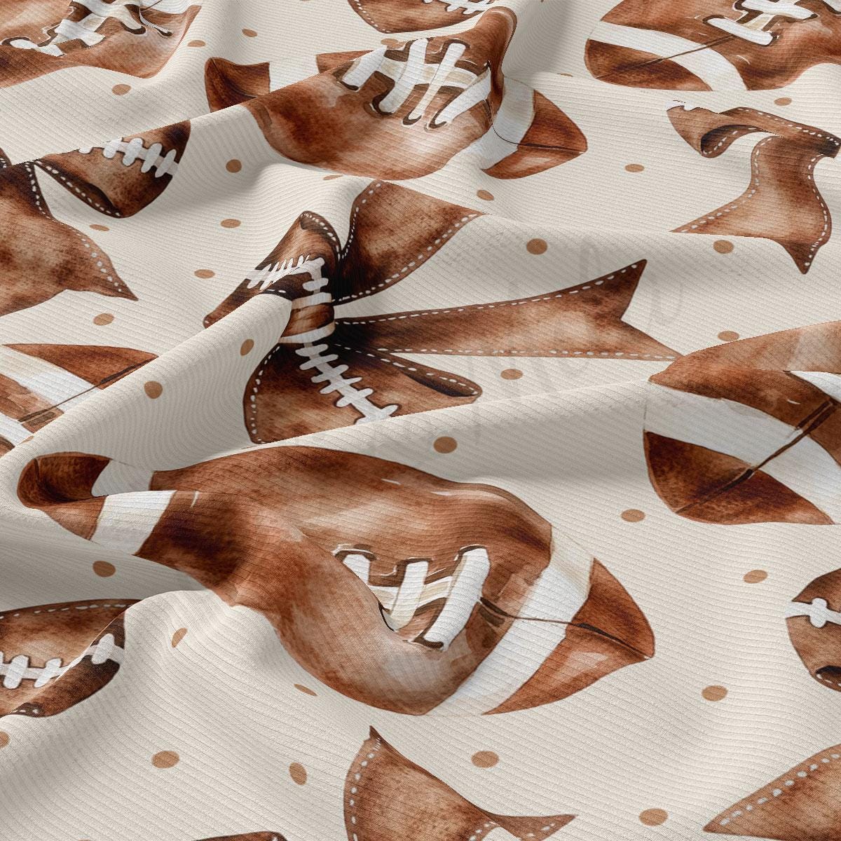 a close-up view of a fabric with a repeating pattern of brown footballs and white polka dots.