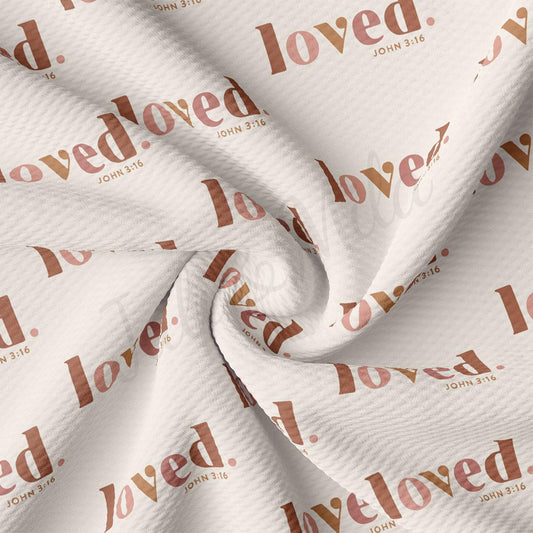 The image is a close-up of a fabric with the word "loved" printed on it in a repeating pattern.