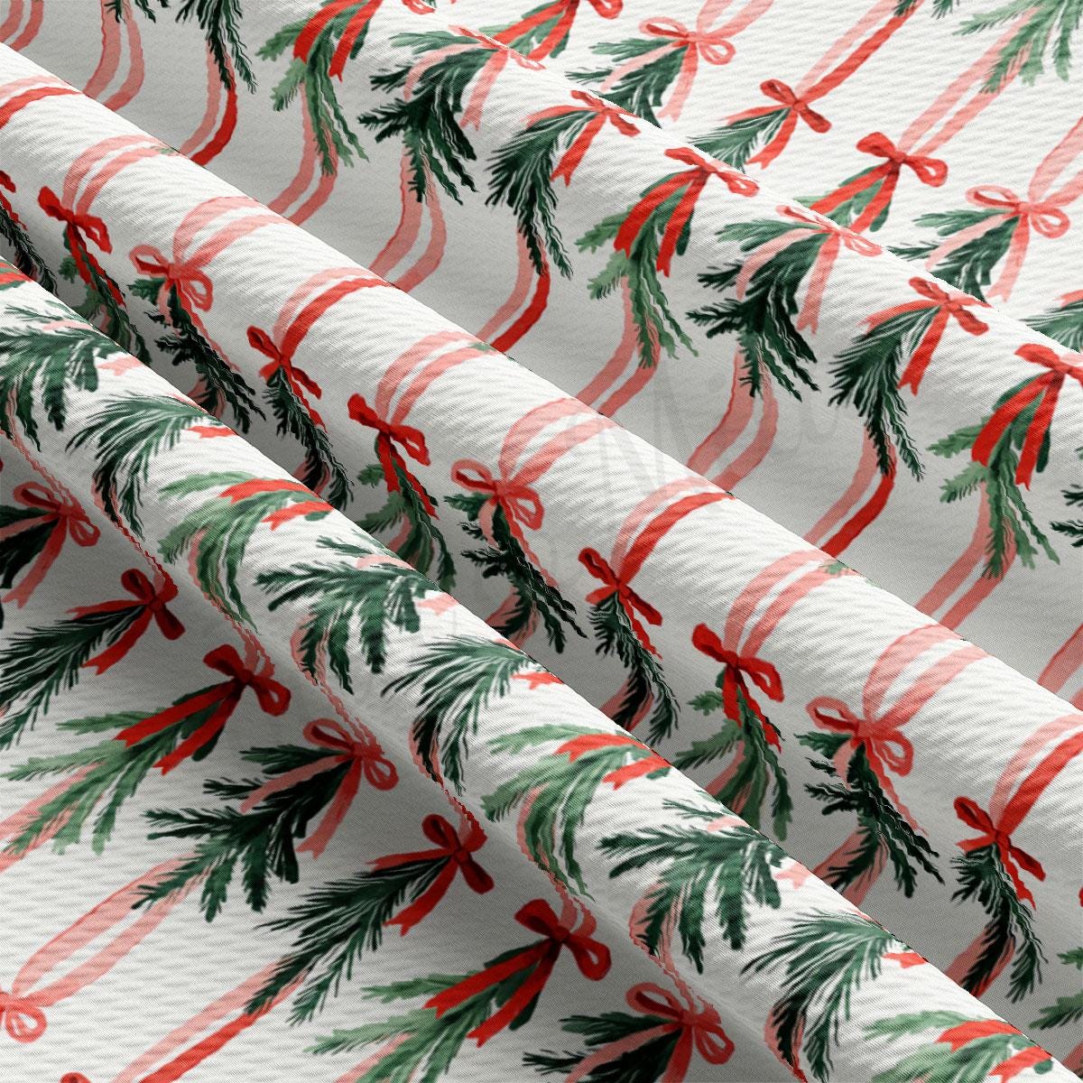 a close-up view of a fabric with a repeating pattern of red and green Christmas bows and pine branches.