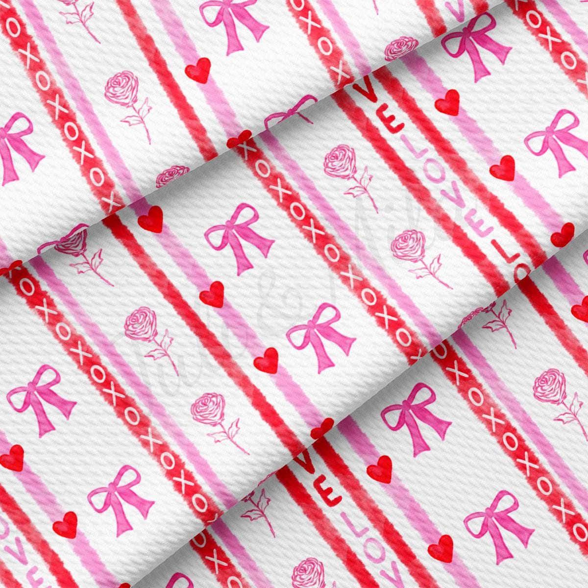 a pink and white striped fabric with hearts and bows