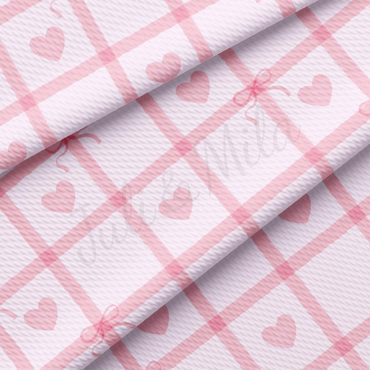 a pink and white checkered fabric with hearts on it