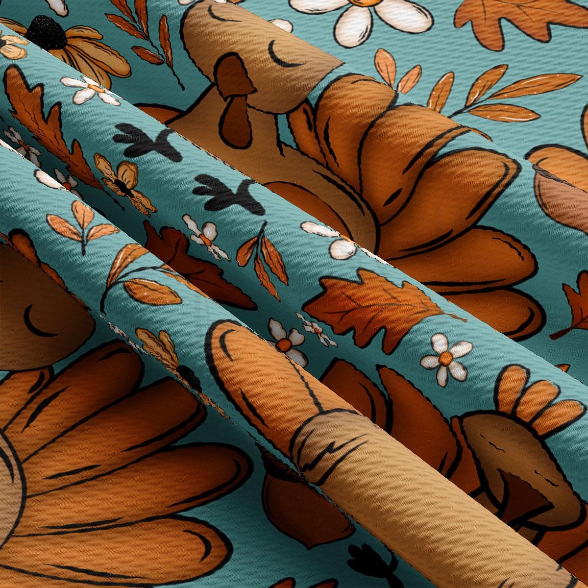 The image is a close-up of a fabric with a repeating pattern of orange flowers and leaves against a blue background.