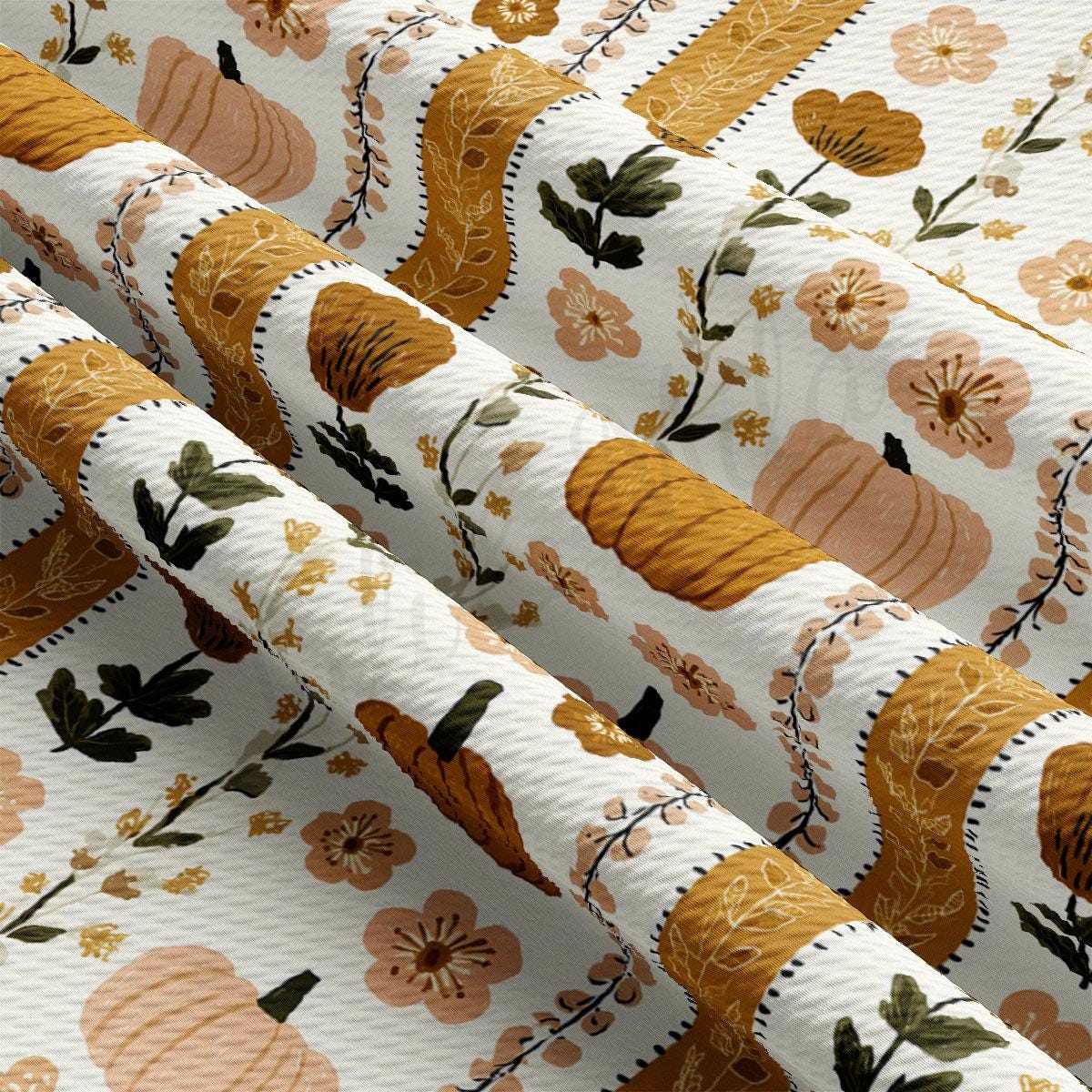 a close-up view of a fabric with a repeating pattern of pumpkins and flowers in shades of orange, brown, and green.