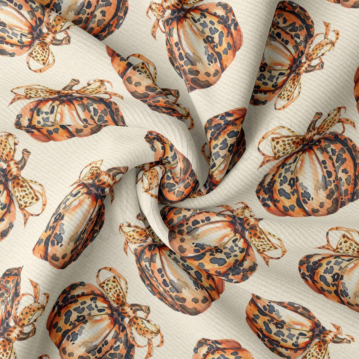 a close-up view of a fabric with a repeating pattern of orange and black spotted pumpkins.