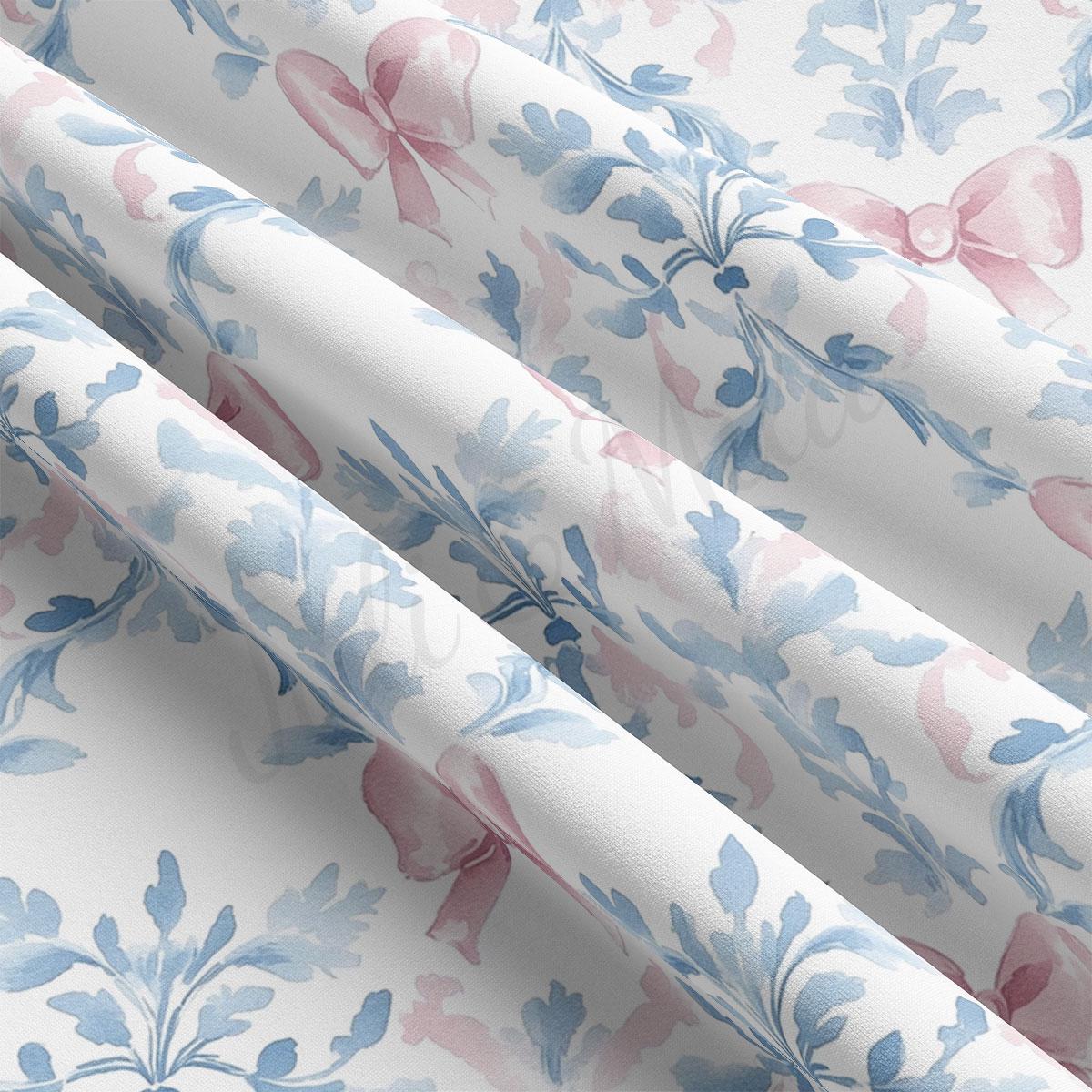 a close-up view of a fabric with a floral pattern in shades of blue and pink. The fabric appears to be folded or rolled, revealing the intricate design of the floral motifs.
