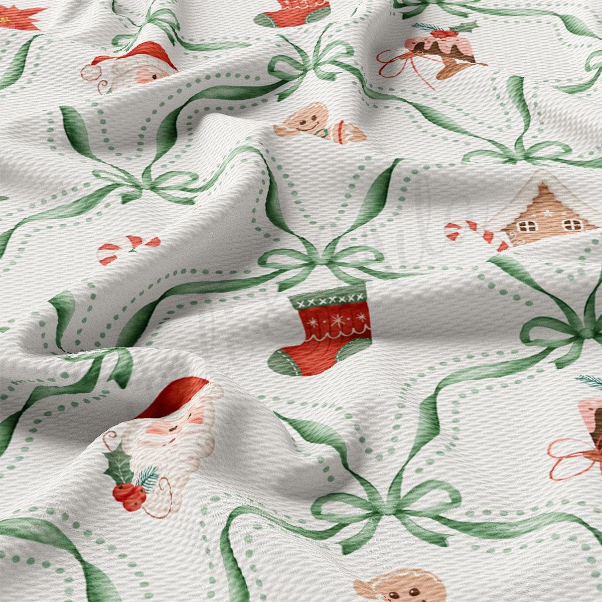 a close-up view of a fabric with a Christmas-themed pattern. The fabric has a white background with green and red accents, and it includes various Christmas-themed illustrations such as Santa Claus, gingerbread houses, and stockings. The fabric appears to be made of a soft, textured material, and it has a slightly wrinkled appearance, giving it a cozy and festive feel.