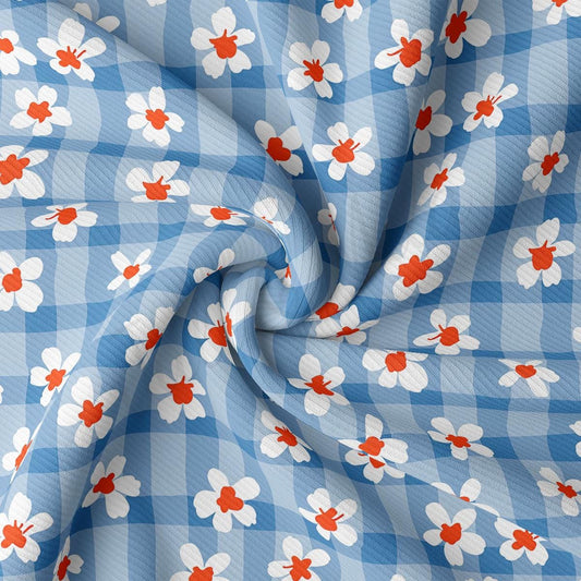 a blue and white checkered fabric with red and white flowers