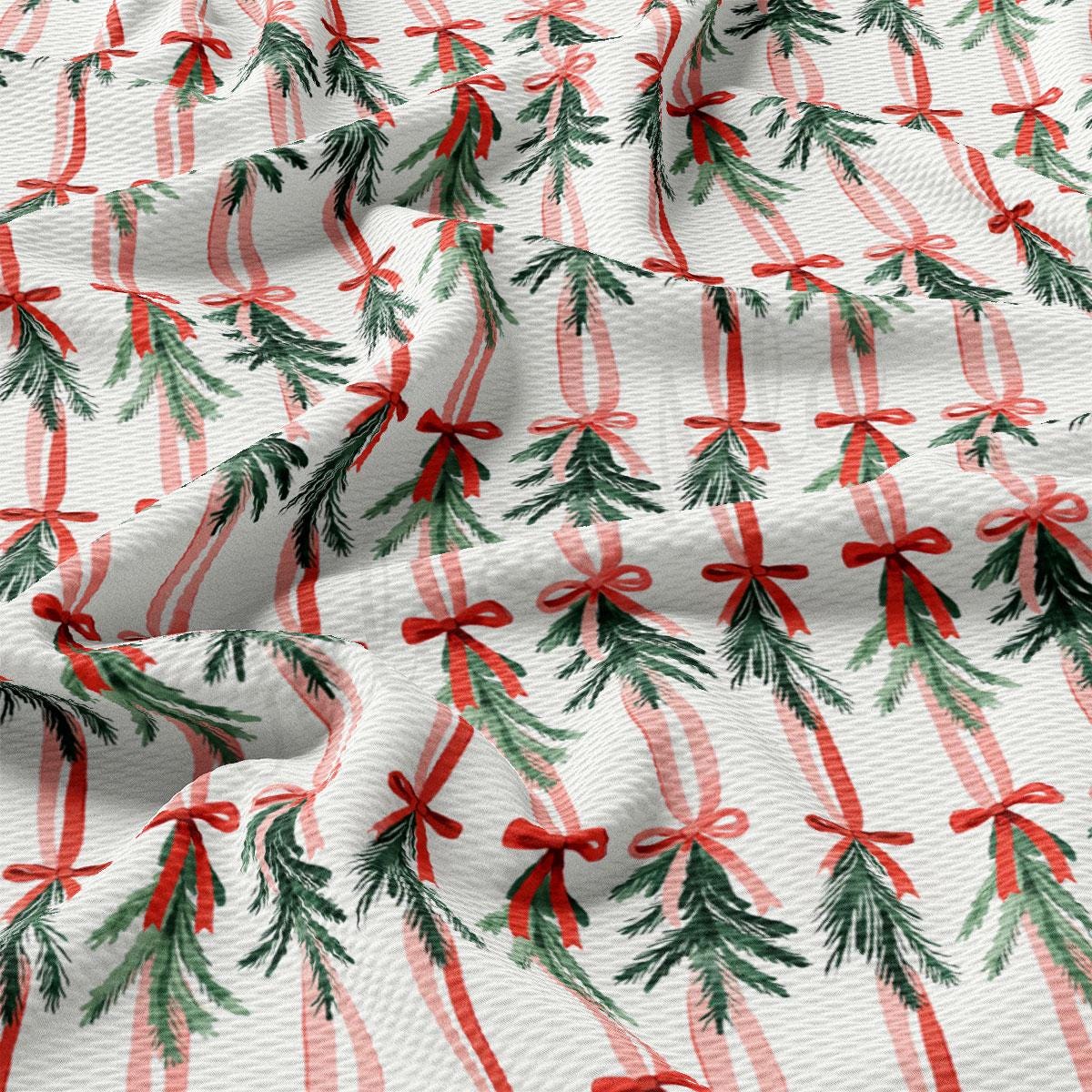 a close-up view of a fabric with a repeating pattern of Christmas trees and red bows.
