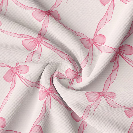 a close-up view of a fabric with a repeating pattern of pink bows on a white background.