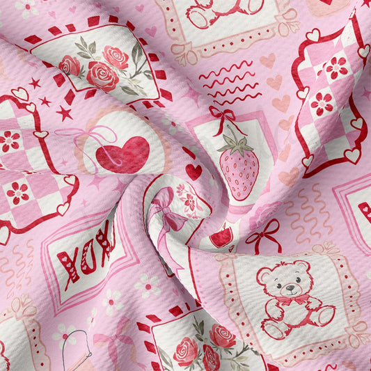 The image is a close-up of a fabric with a pink and white color scheme, featuring various decorative elements such as hearts, flowers, and a teddy bear.