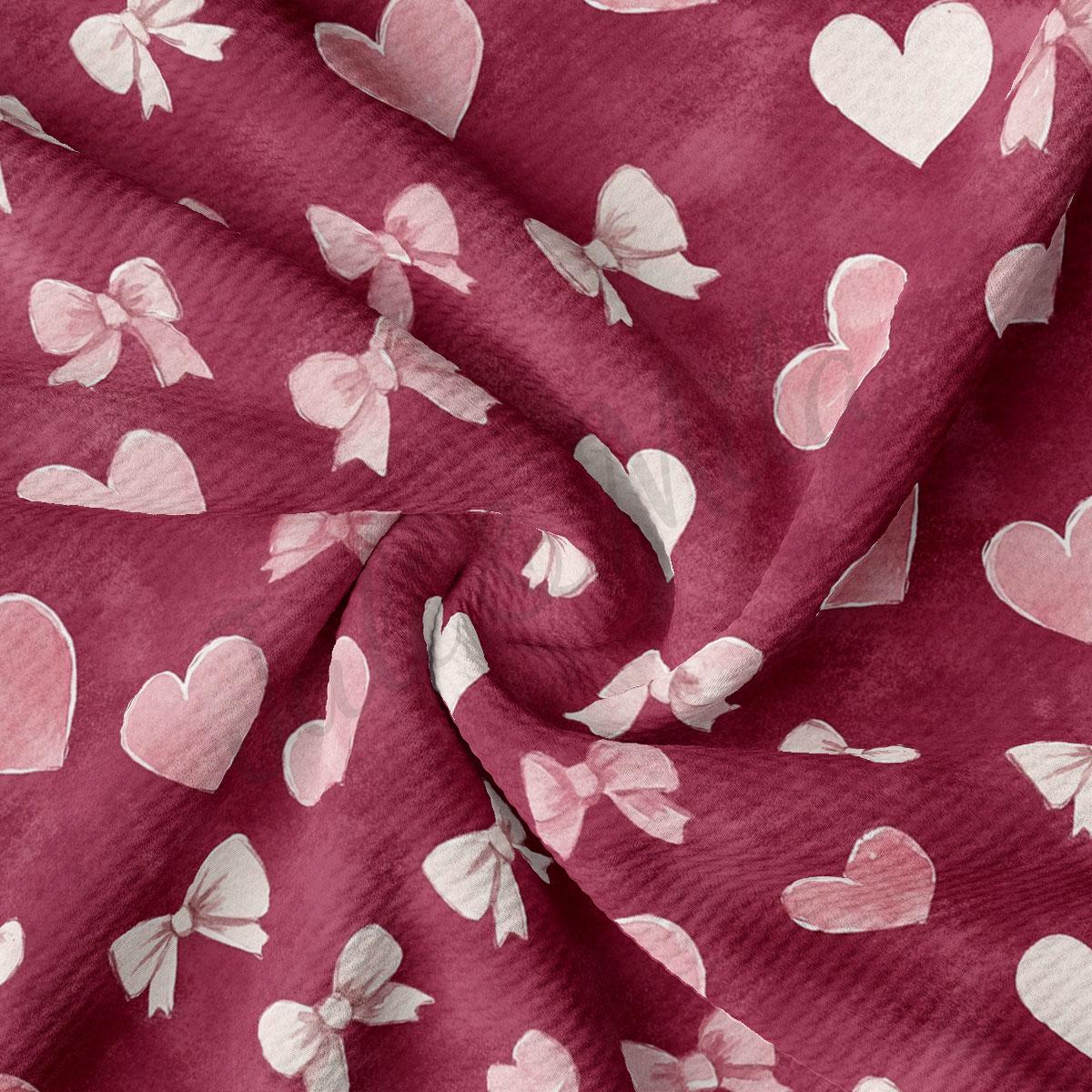 a close-up view of a fabric with a repeating pattern of pink hearts and white bows.