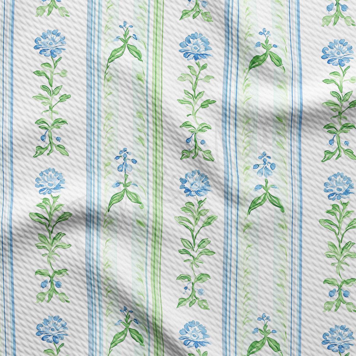 a repeating pattern of blue and green floral designs on a white background, with each design consisting of a flower and green leaves.