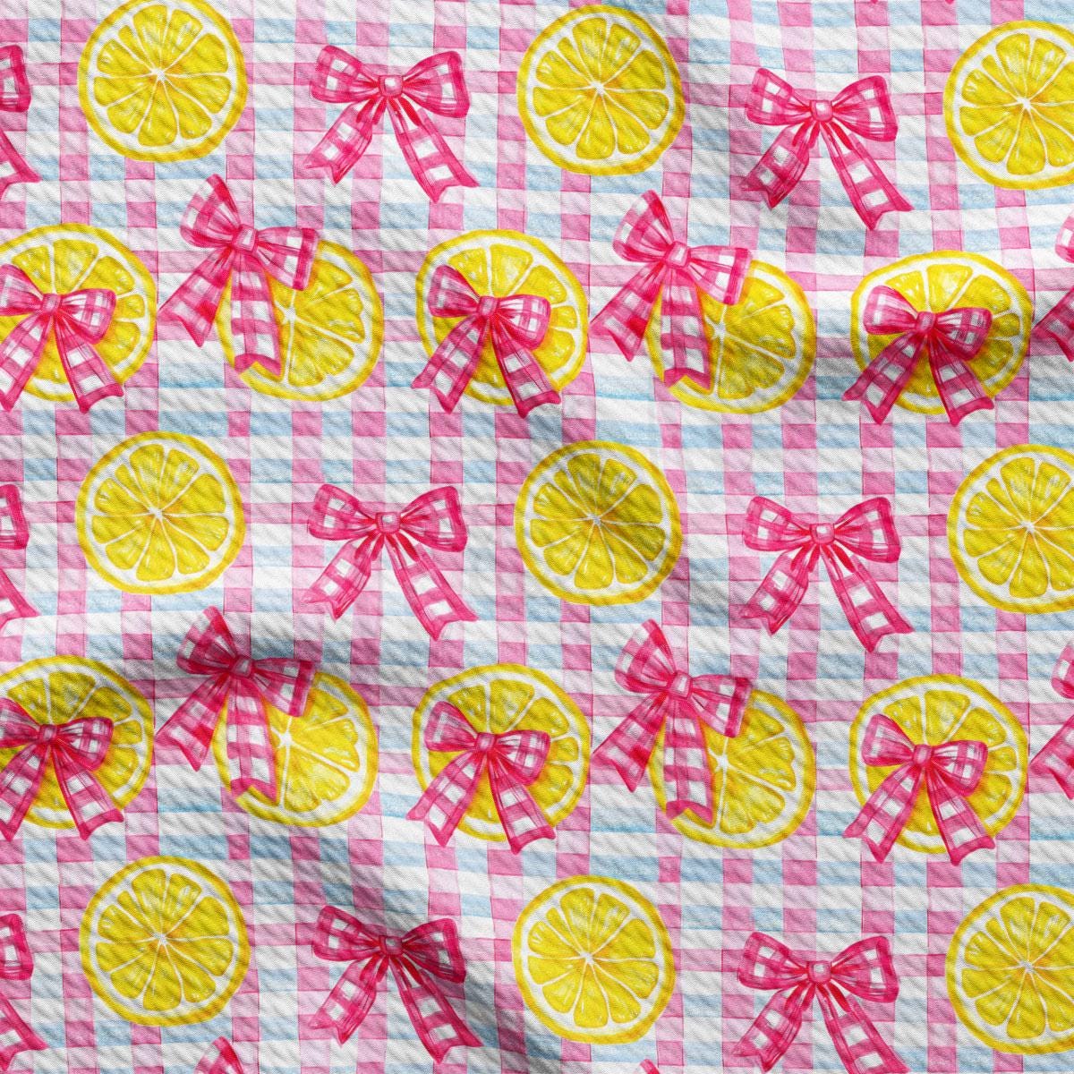 a pink and white checkered fabric with lemons and bows
