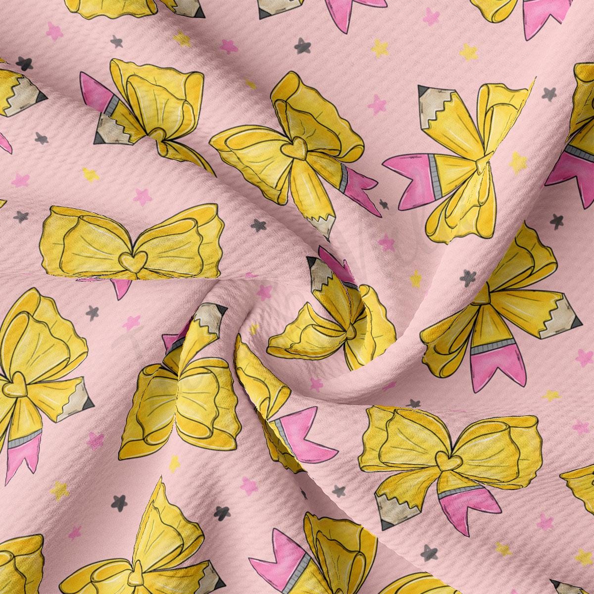 a close-up view of a fabric with a repeating pattern of yellow bows and pink pencils against a pink background.