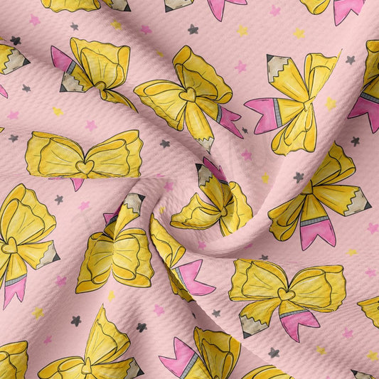 a close-up view of a fabric with a repeating pattern of yellow bows and pink pencils against a pink background.