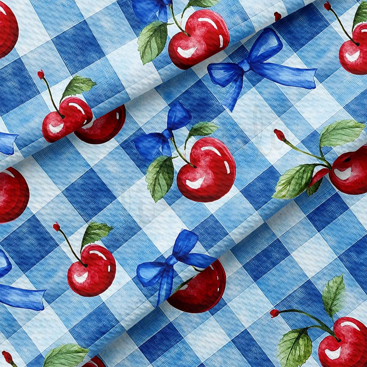 a blue and white checkered table cloth with cherries on it