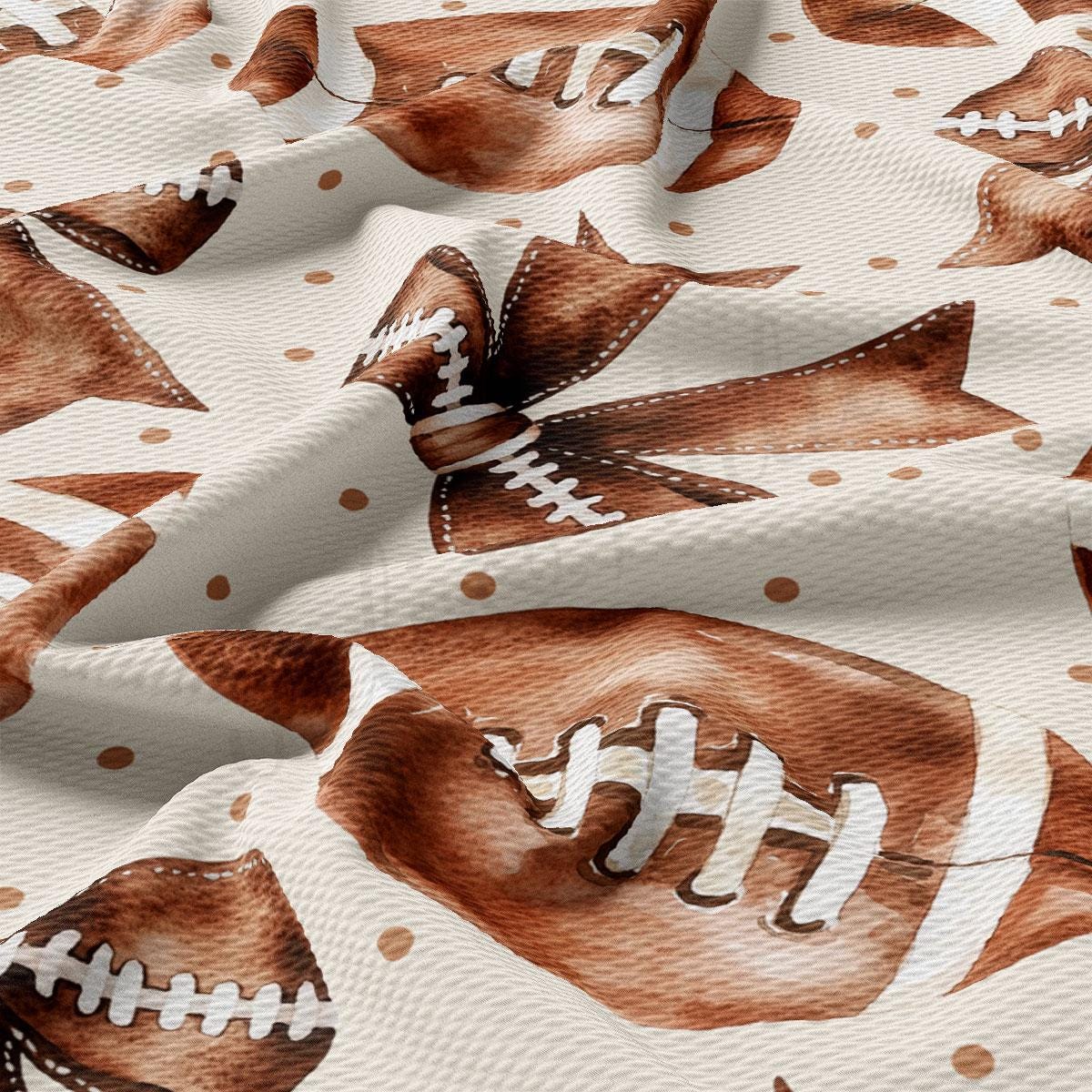 a close-up view of a fabric with a repeating pattern of brown footballs and white polka dots.