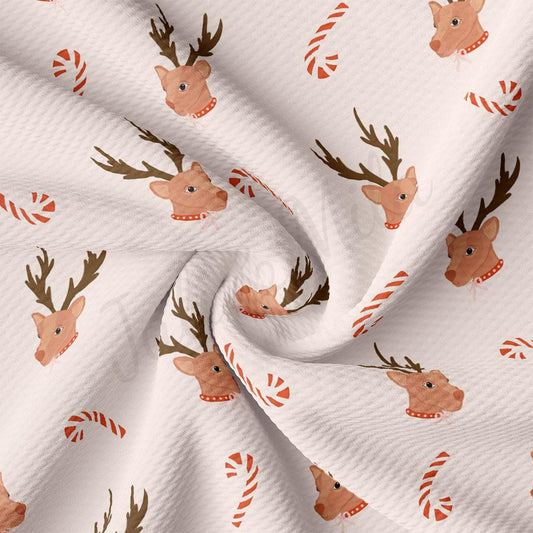a white fabric with reindeers and candy canes on it